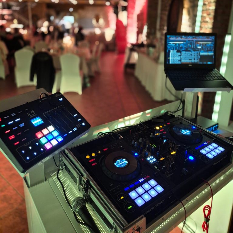 Event DJ - DJ Henne - Licht-und Tontechnik DJ-Setup mit Mixer und Laptop, umgeben von einem eleganten Event-Ambiente.