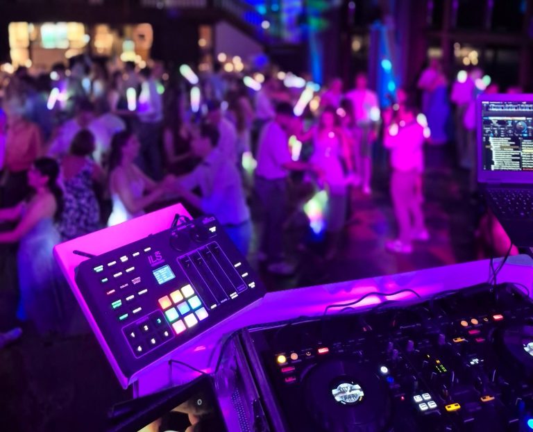 Hochzeits DJ - DJ Henne Menschen tanzen in einem festlichen, bunt beleuchteten Raum.